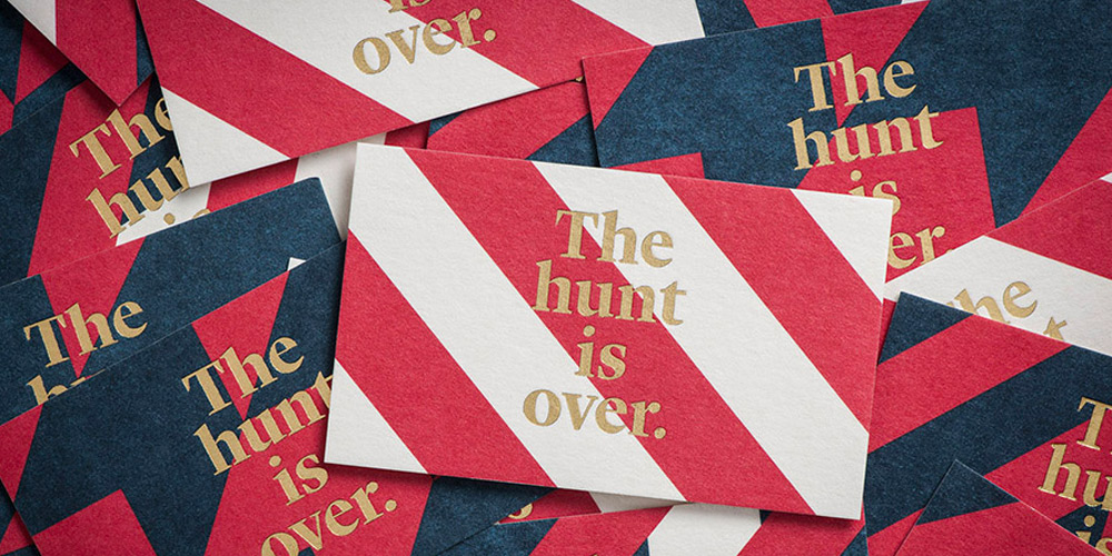 Red, white, and blue cards with gold text reading 'The hunt is over'