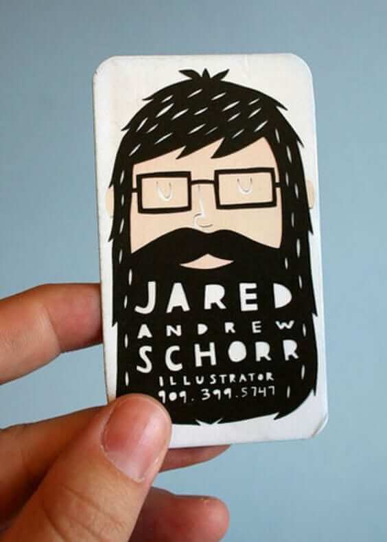 a hand holding up a business card with a picture of a man with a beard.
