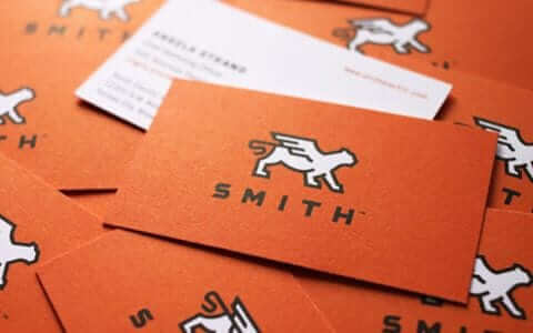 a pile of orange business cards sitting on top of each other.