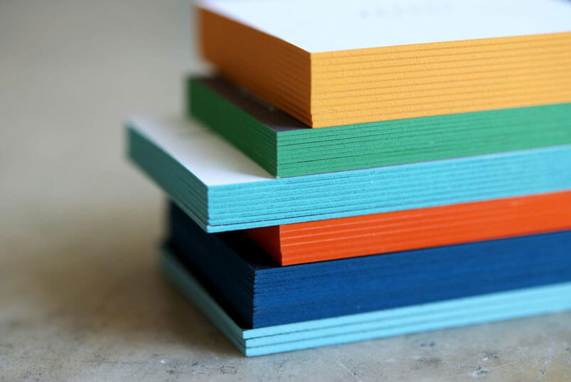 a stack of multicolored paper sitting on top of a table.