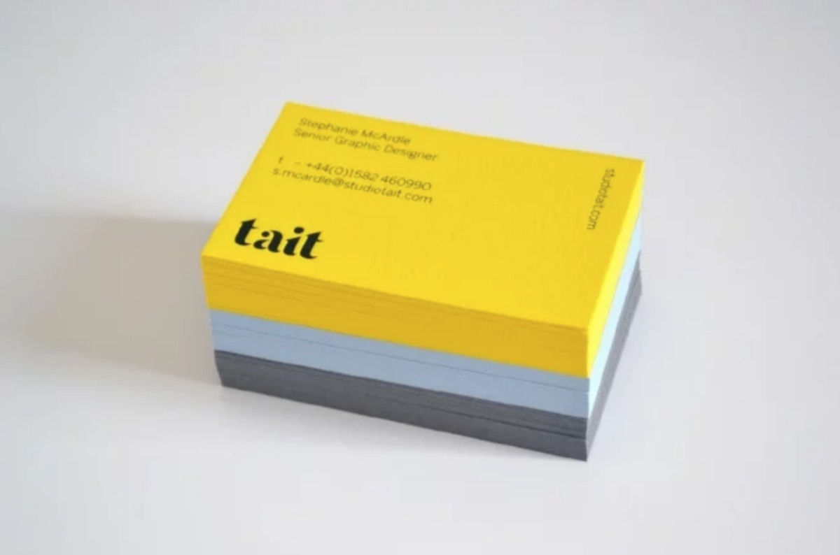 a stack of yellow and gray business cards.